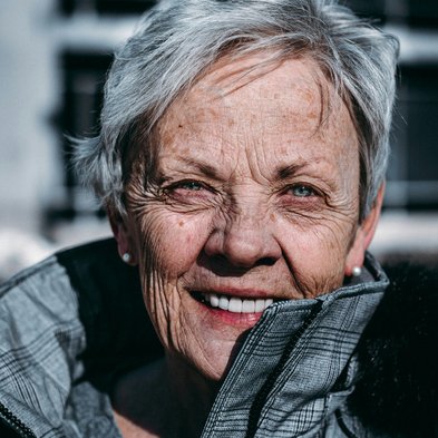 Foto von Ravi Patel auf Unsplash Frau mit grauen Haaren und Jacke